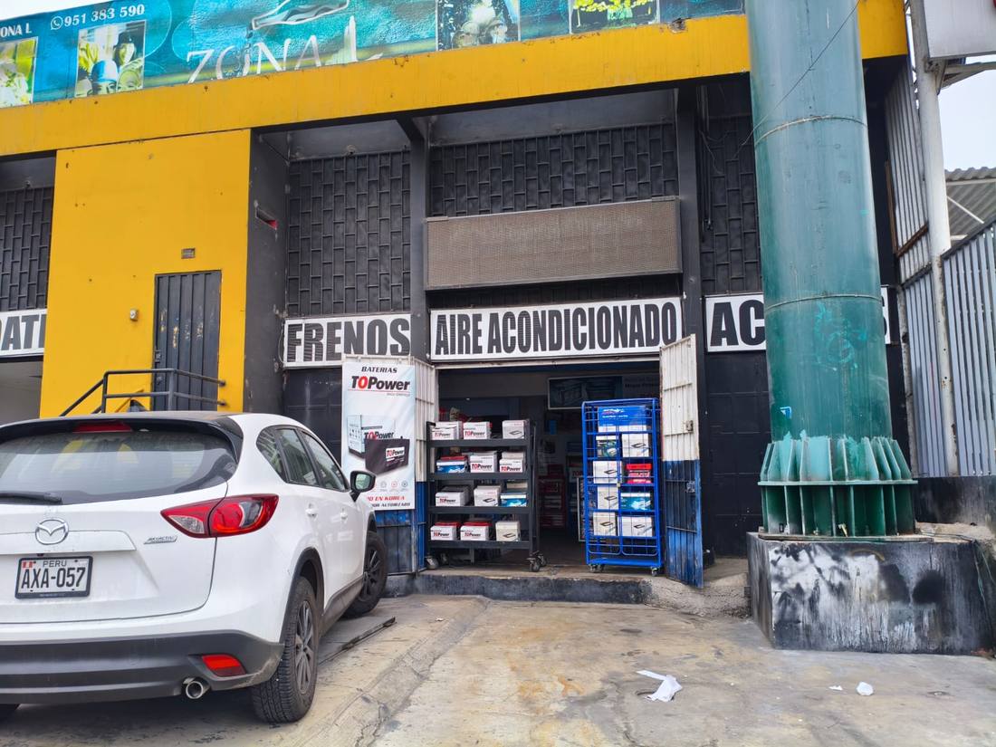 Fachada del taller con áreas de frenos y aire acondicionado